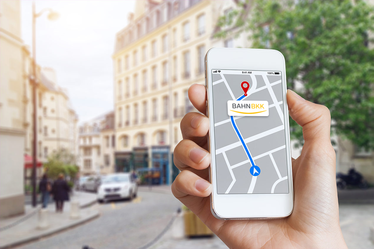 Jemand hält ein Handy mit Karten-App in der Hand