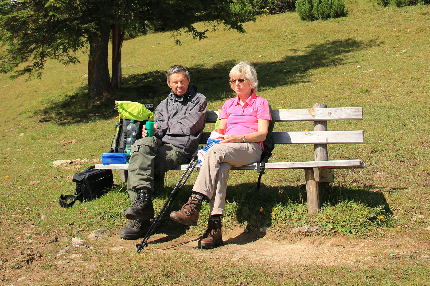 Älteres Paar macht auf einer Bank Pause beim Wandern