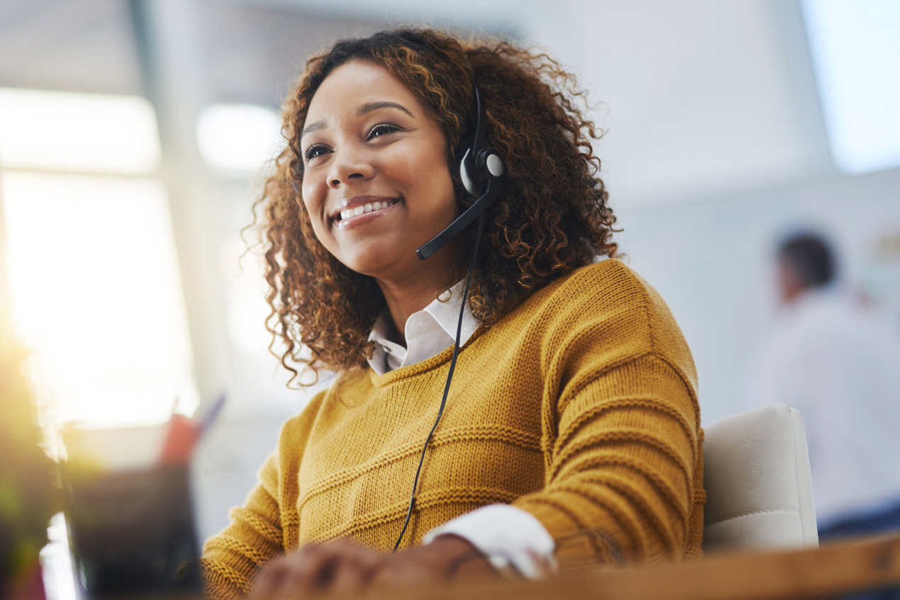 Frau telefoniert mit Headset im Büro