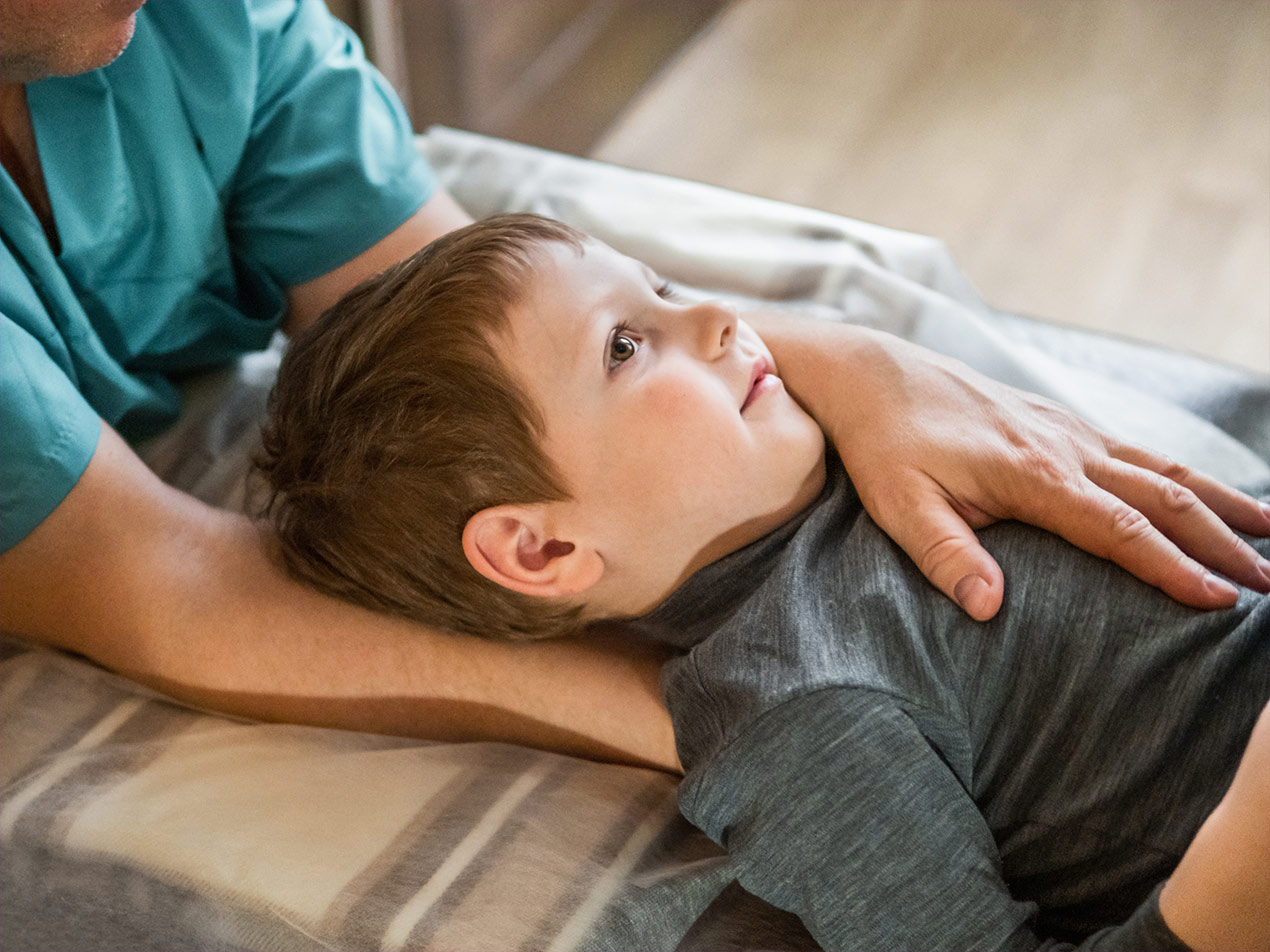 Junge wird osteopathisch behandelt.