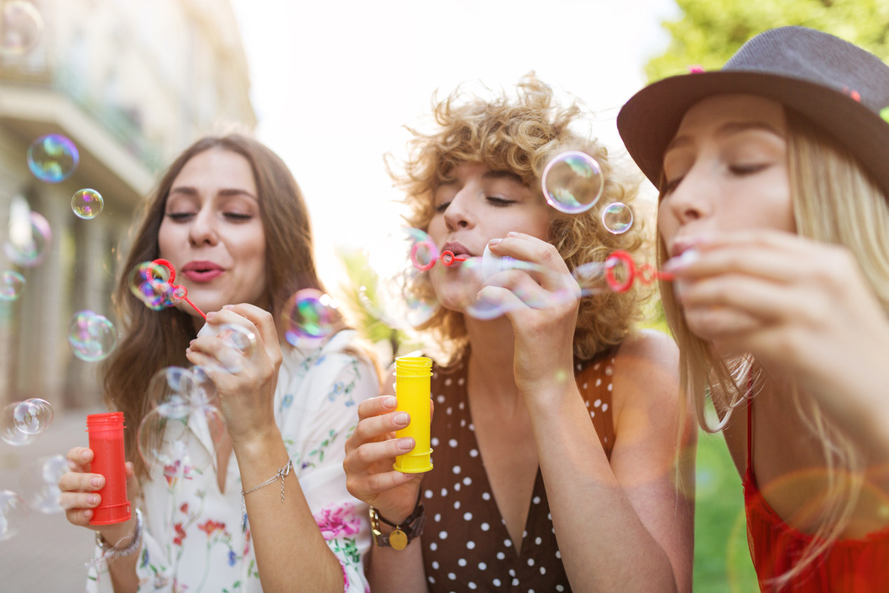 Gruppe von 3 Frauen, de Seifenblasen machen