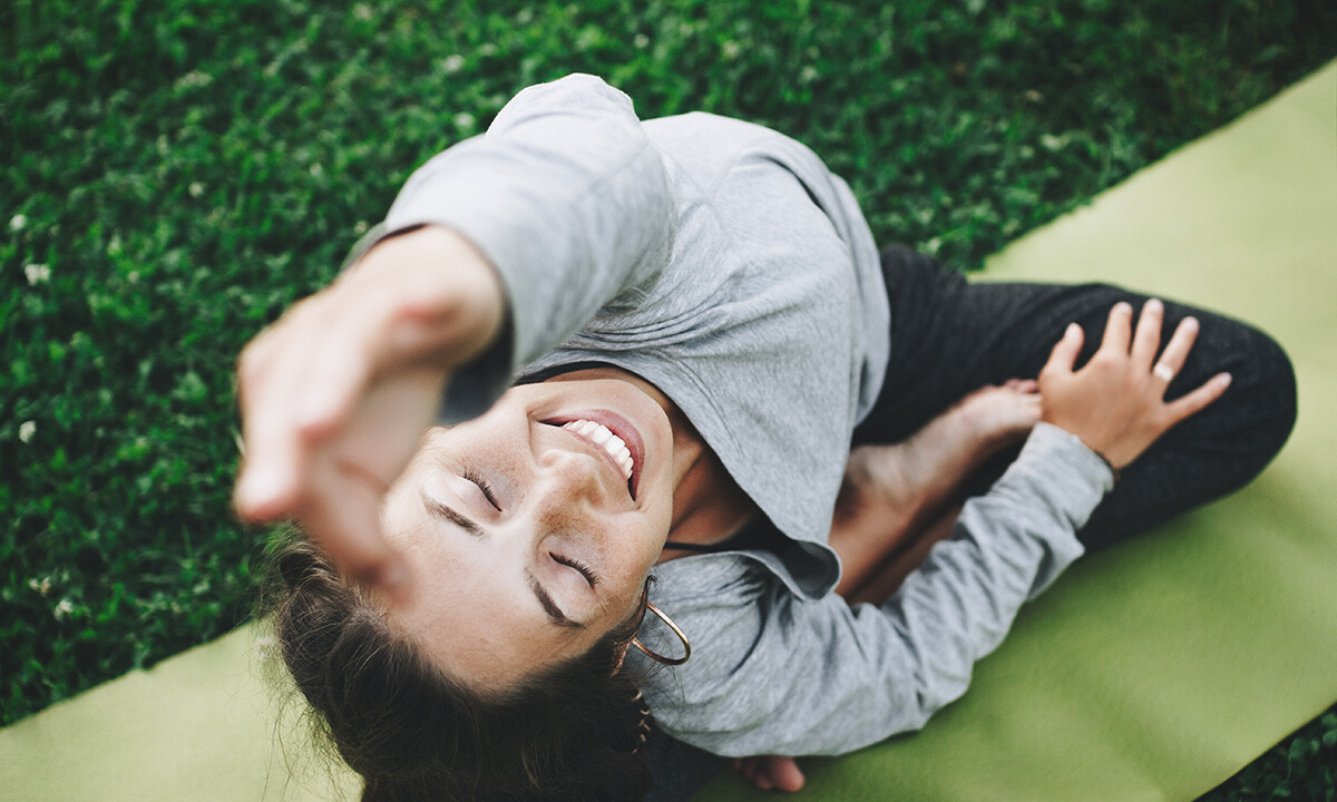 Frau, die bei einer Gesundheitsreise an einer Yogastunde im Freien teilnimmt