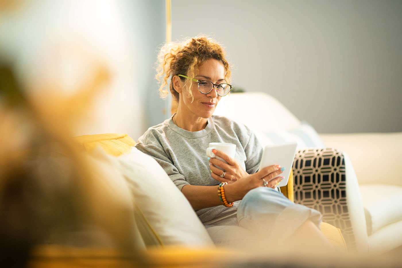 Frau auf der Couch, die auf einen Zettel schaut