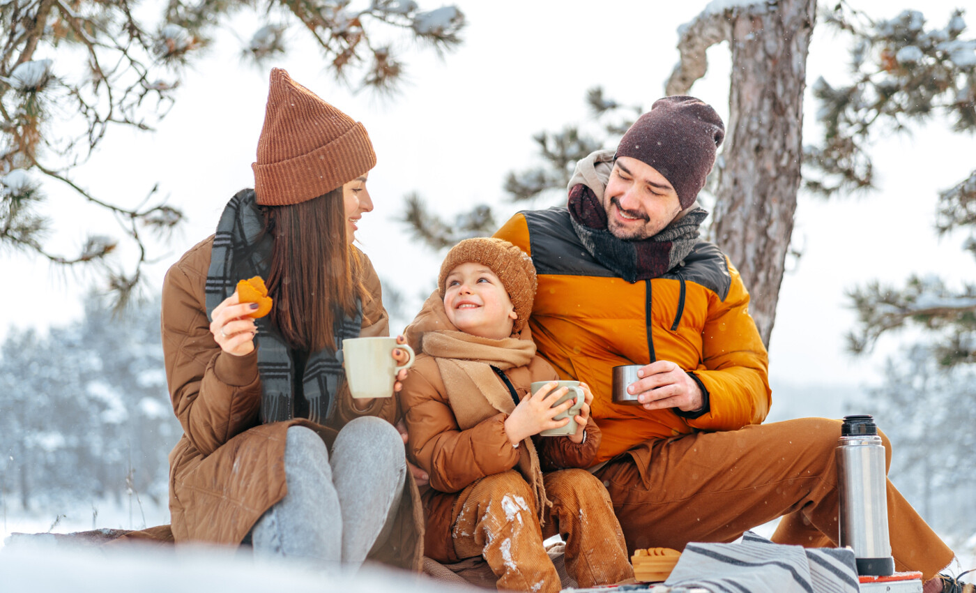 Familie trinkt Tee im Schnee