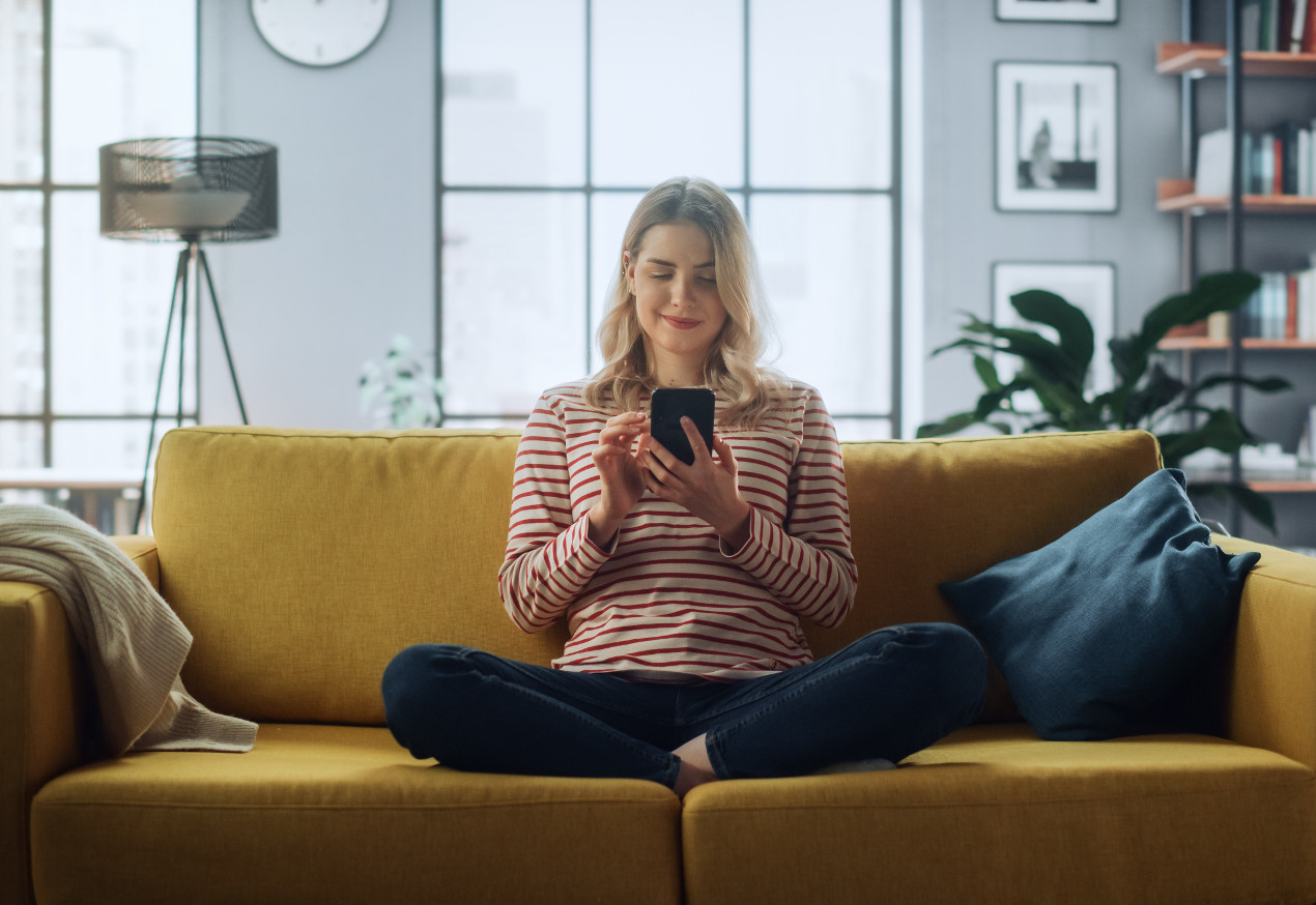 Frau mit einem Smartphone auf der Couch