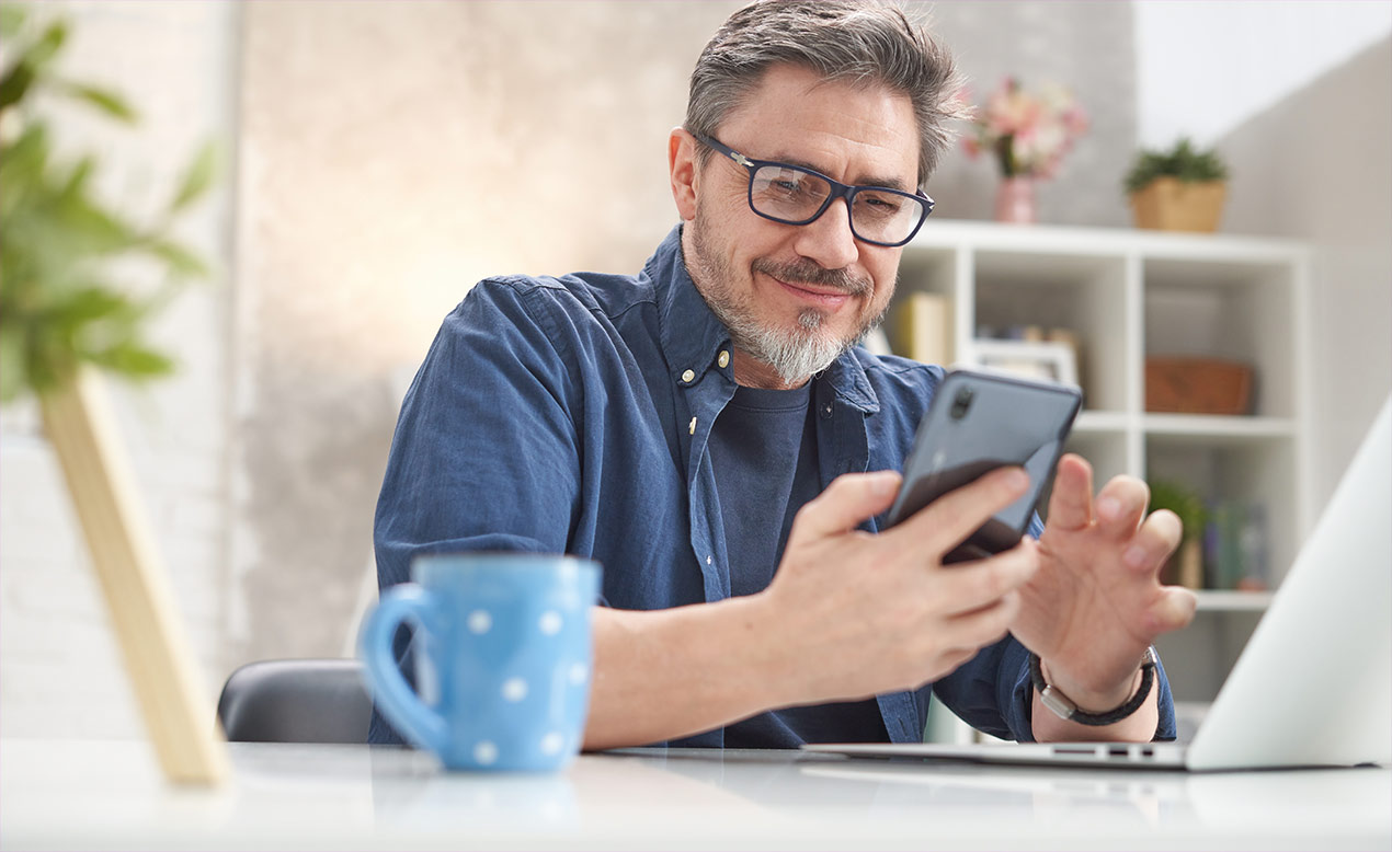 Mann tippt auf seinem Smartphone.